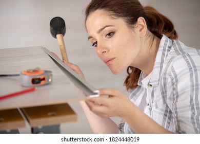 Female Tiler Using Mallet To Fit Edging Strip