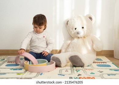 Female Toddler Playing With A Rainbow Stacker Toy At Home. Montessori Playroom.