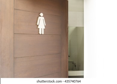 Female Toilet Sign On Wooden Door.