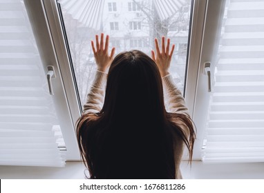 Female Touches Hands To The Window Glass, Concept Of Quarantine Or House Arrest