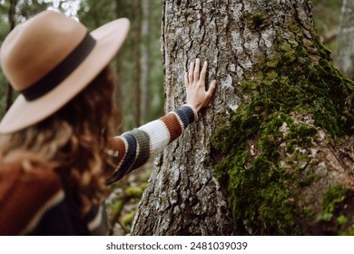 Female tourist with backpack and travel equipment touching tree while standing in the forest. Concept to love nature and tree . Environment ecology and Earth Day concept. - Powered by Shutterstock