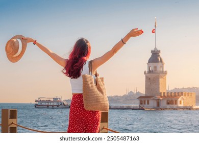 A female tourist explores Istanbul, admiring the iconic architecture of the Maiden Tower against the backdrop of the vibrant cityscape. - Powered by Shutterstock