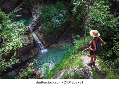 Female Tourist Hiker Admiring Fratarca Canyon And Beautiful Waterfalls in Log Pod Mangartom, Julian Alps Slovenia - Powered by Shutterstock