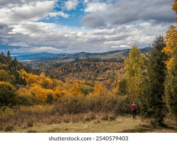 A female tourist hiking along a rocky trail in a colorful autumn forest, Pieniny mountain range, Poland - Powered by Shutterstock