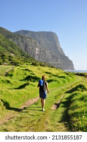 Female tourist hiking on Lord Howe Island with Mount Gower in the background, New South Wales, Australia