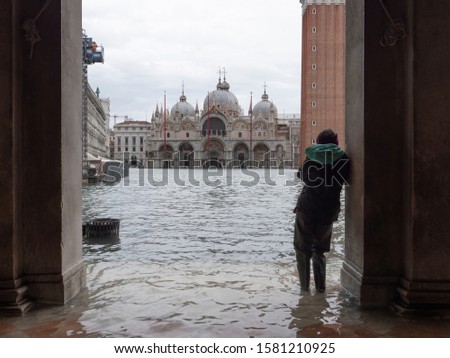 Female tourist standing under an arch contemplating the flood in st mark’s square, Venice. 4k
