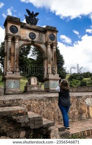 Female tourist taking pictures at the Arch of Triumph in Boyaca built in memory of the 3 races Mestizo, Creole and Spanish which participated in the process of independence of Colombia.