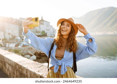 Female tourist taking selfie photos on sightseeing.  Selfie time. Lifestyle, adventure, nature, active life. - Powered by Shutterstock