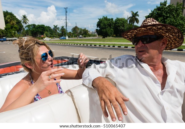 Female\
tourist talking with a cab driver in the\
Havana
