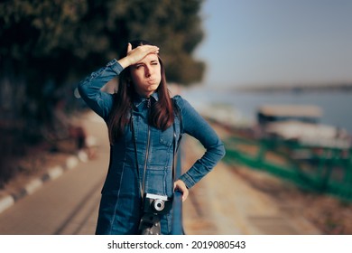 Female Tourist With Vintage Hipster Camera Forgetting Film Roll. Woman Trying To Remember Something Standing And Waiting In A Harbor
