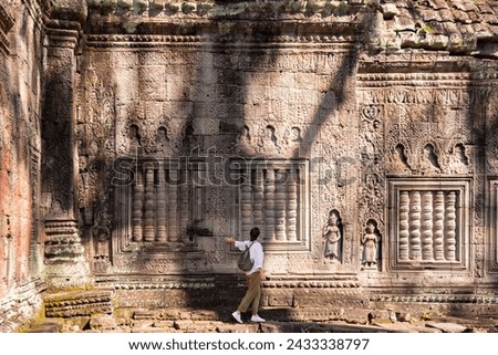 Female tourist visiting ancient Angkor temple in Cambodia