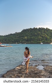 Female Tourist Wear Swimming Suit And Stand Alone At Rock On The Beach