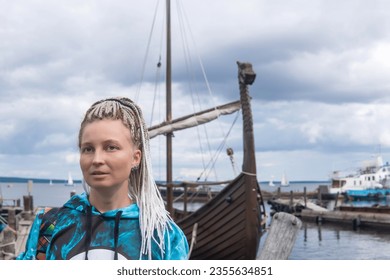 female tourist went ashore after sailing in a modern replica of anсient Viking longship - Shutterstock ID 2355634851