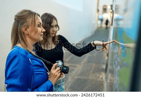 Similar – Image, Stock Photo Twin sisters laughing at a postcard in Erfurt