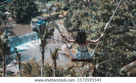 Female tourists swinging on beautiful natural place in Ubud, Bali, Indonesia.