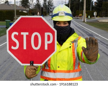 Female Traffic Control Flagger At Work Holding A Stop Sign
