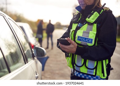 Female Traffic Police Officer Recording Details Of Road Traffic Accident On Mobile Phone