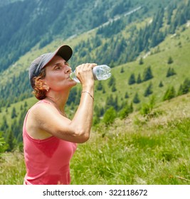 Female Trail Runner Drinking Water And Having A Break