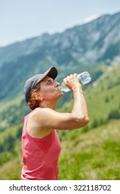 Female Trail Runner Drinking Water And Having A Break