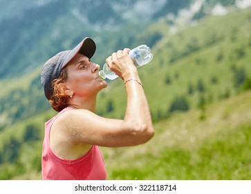 Female Trail Runner Drinking Water And Having A Break