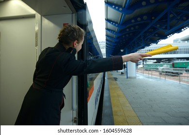 Female train conductor signaling departure of the passenger train standing on the platform. The Grand Central train station. December 22, 2019. Kiev, Ukraine