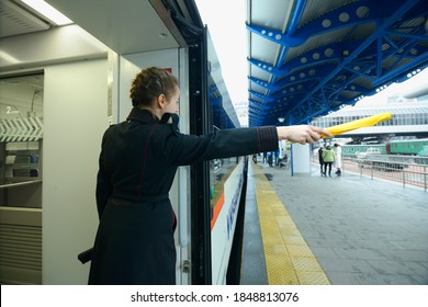 Female Train Conductor Signaling Departure Of The Passenger Train Standing On The Platform. The Grand Central Train Station. December 22, 2019. Kiev, Ukraine