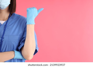 Female Trainee Nurse In Gloves And Mask On Pink Background