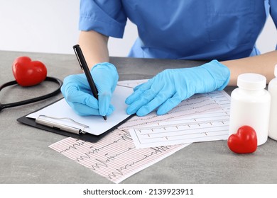 Female Trainee Nurse Writes Prescription In Clipboard