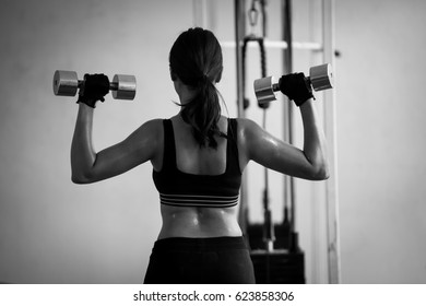 Female trainer hold dumbbell in hand, concept.black and white - Shutterstock ID 623858306