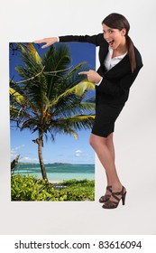 Female Travel Agent Showing Poster Of Tropical Beach