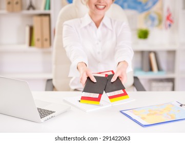 Female Travel Agent Sitting At Office And Holding Tickets. Close-up.