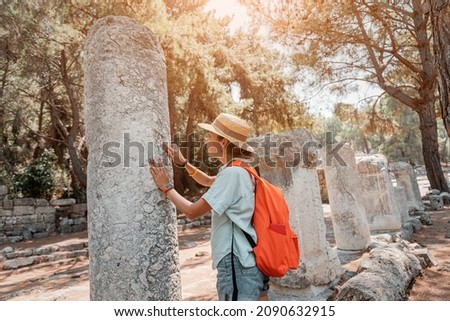 Female traveler walks through the ancient ruins of the antic Greek city of Phaselis in Turkey. Historical sights and archeology