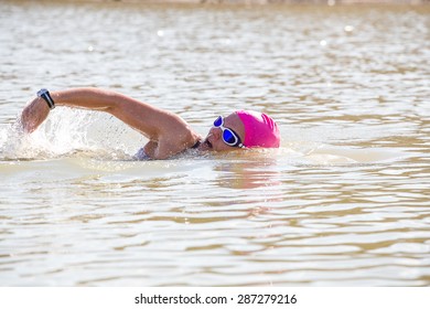 Female Triathlete Swimming In A Dam While Training For A Triathlon.