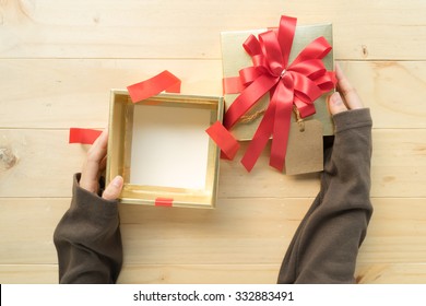 A Female Two Hands Opening The Empty(blank) Gift Box On Wooden Table, Top View.