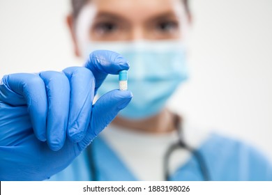 Female UK GP ICU General Practitioner Doctor Wearing Protective Face Mask,gloves,holding Antibiotic Pill,macro Detail Focus,patient Cure And Remedy For Illness Or Disease,prescription Drug Concept