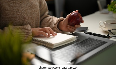 A Female University Student Eating Apple While Studying Math On Online Class At Home. Remote Work, Quarantine.