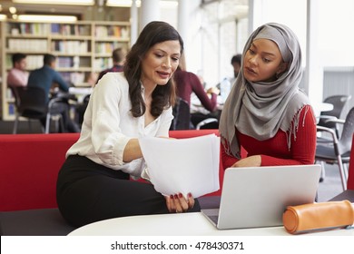 Female University Student Working In Library With Tutor - Powered by Shutterstock