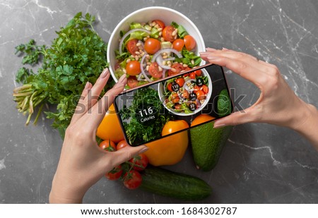 Female using dieting app on a smartphone to track nutrition facts and calories in her food