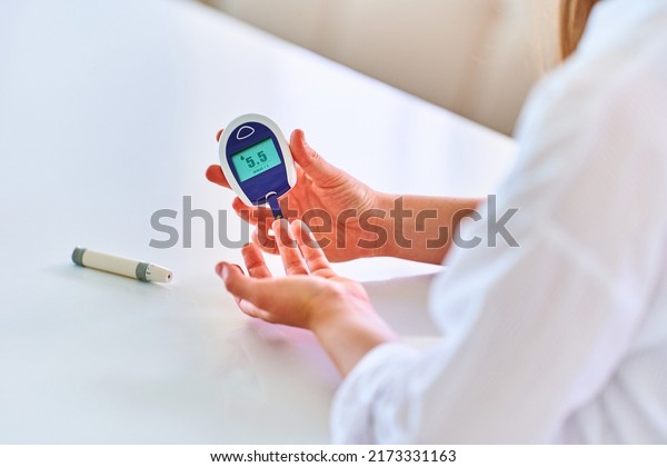 Female using\
glucose meter for measuring and monitoring blood level. Healthcare\
and mellitus diabetes treatment\
