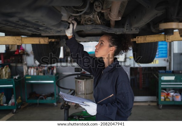 Female using laptop at Service center,\
car repair, tire change. Mechanic changing engine, service car\
workshop automobile. professional man shop\
maintenance	