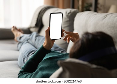 Female using phone. Over shoulder view of young woman lying on sofa hold smartphone with blank empty screen. Template for web app chat interface online advertisement mobile game social network profile - Shutterstock ID 2082214768