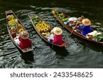 Female vendors on their boat(sampan) in narrow canals for sale their products such as fruits,food or souvenir in   "Damnoen Saduak Floating market" the most famous floating market in Thailand.