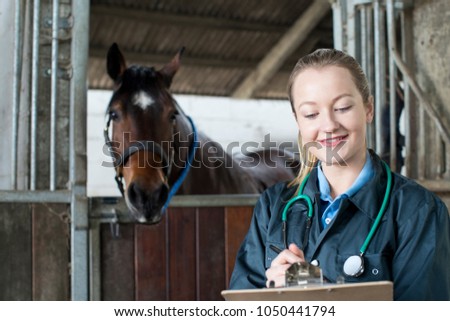 Female Vet Examining Horse In Stable