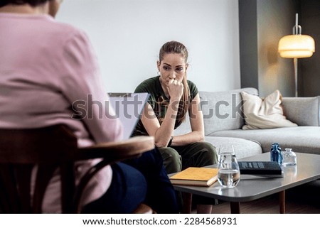 Female veteran soldier having therapy meeting with senior female psychologist.