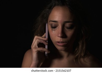 Female Victim Of Domestic Abuse Phoning Support Group. Calling For Help.