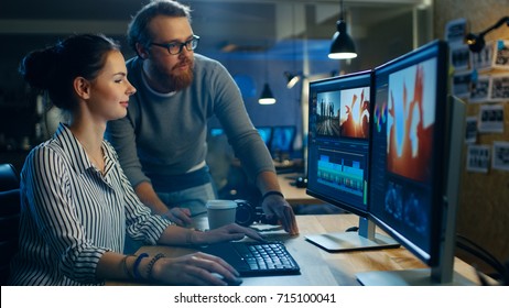 Female Video and Sound Editor Works With Her Male Colleague on a Project on Her Personal Computer with Two Displays. They Work in a Creative Loft Office. - Shutterstock ID 715100041