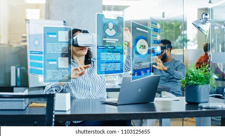 Female Virtual Reality Engineer/ Developer Wearing Virtual Reality Headset Creates Content With Her Colleagues. Bright Young People Work with Holograms in the Augmented & Mixed Reality Project.