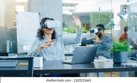 Female Virtual Reality Engineer/ Developer Wearing Virtual Reality Headset Creates Content With Her Colleagues. Bright Young People Work on the Augmented & Mixed Reality Project.