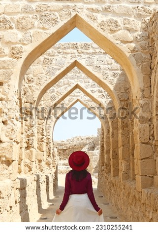 Female Visitor Walking Along the Iconic Archways of Qal'at al-Bahrain Or the Portuguese Fort in Manama, Bahrain