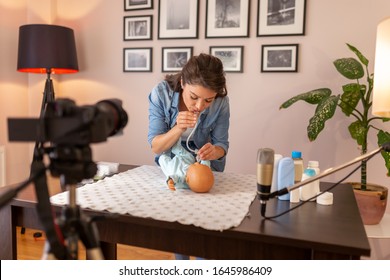 Female Vlogger Recording Tutorial About Newborn Baby Nose Mucus Suction With A Rubber Suction Bulb  As Part Of Online Prenatal Classes Course